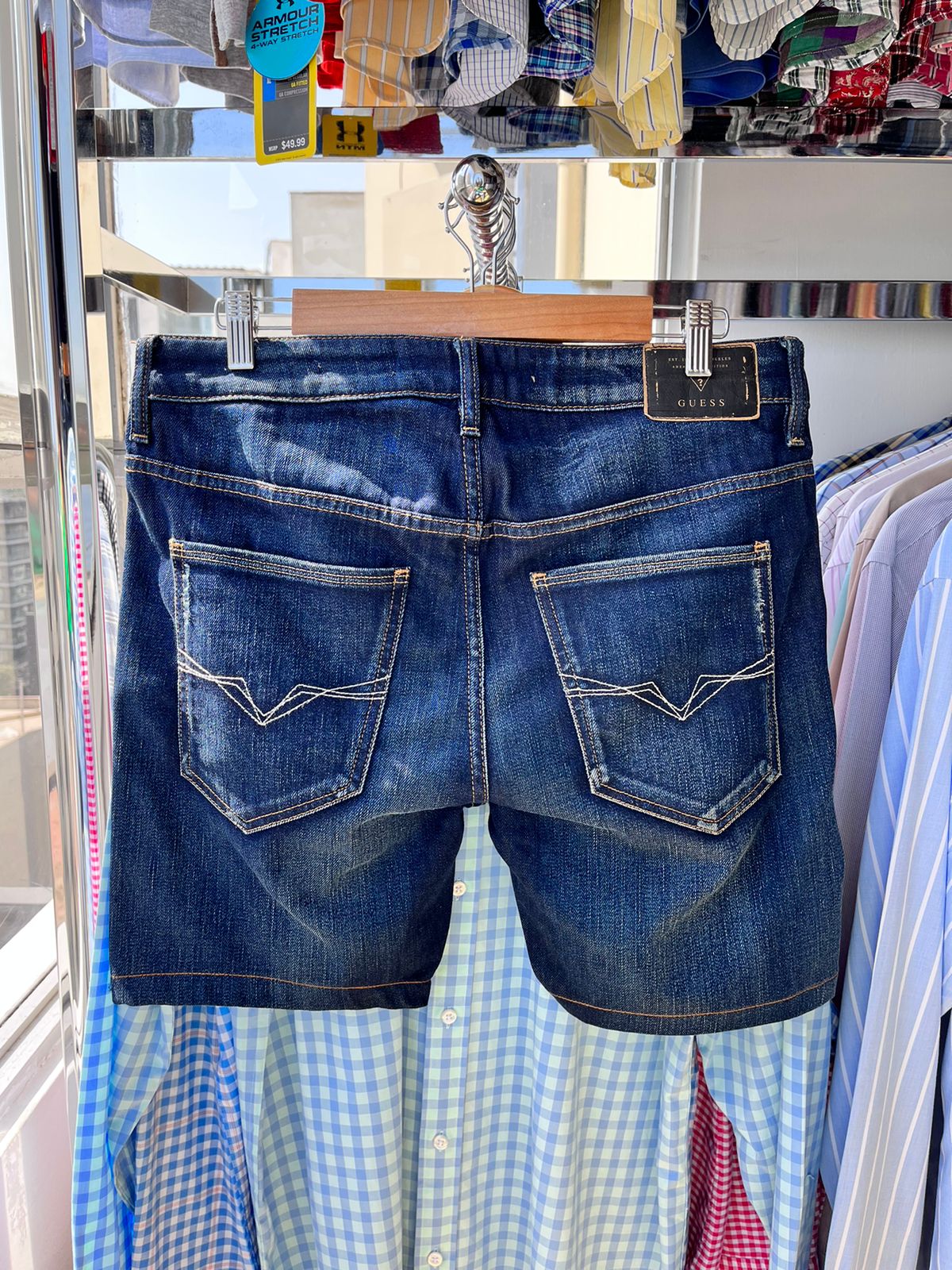 Shorts de hombre Guess, denim lavado medio, diseño de 5 bolsillos, logo triangular en bolsillo delantero.