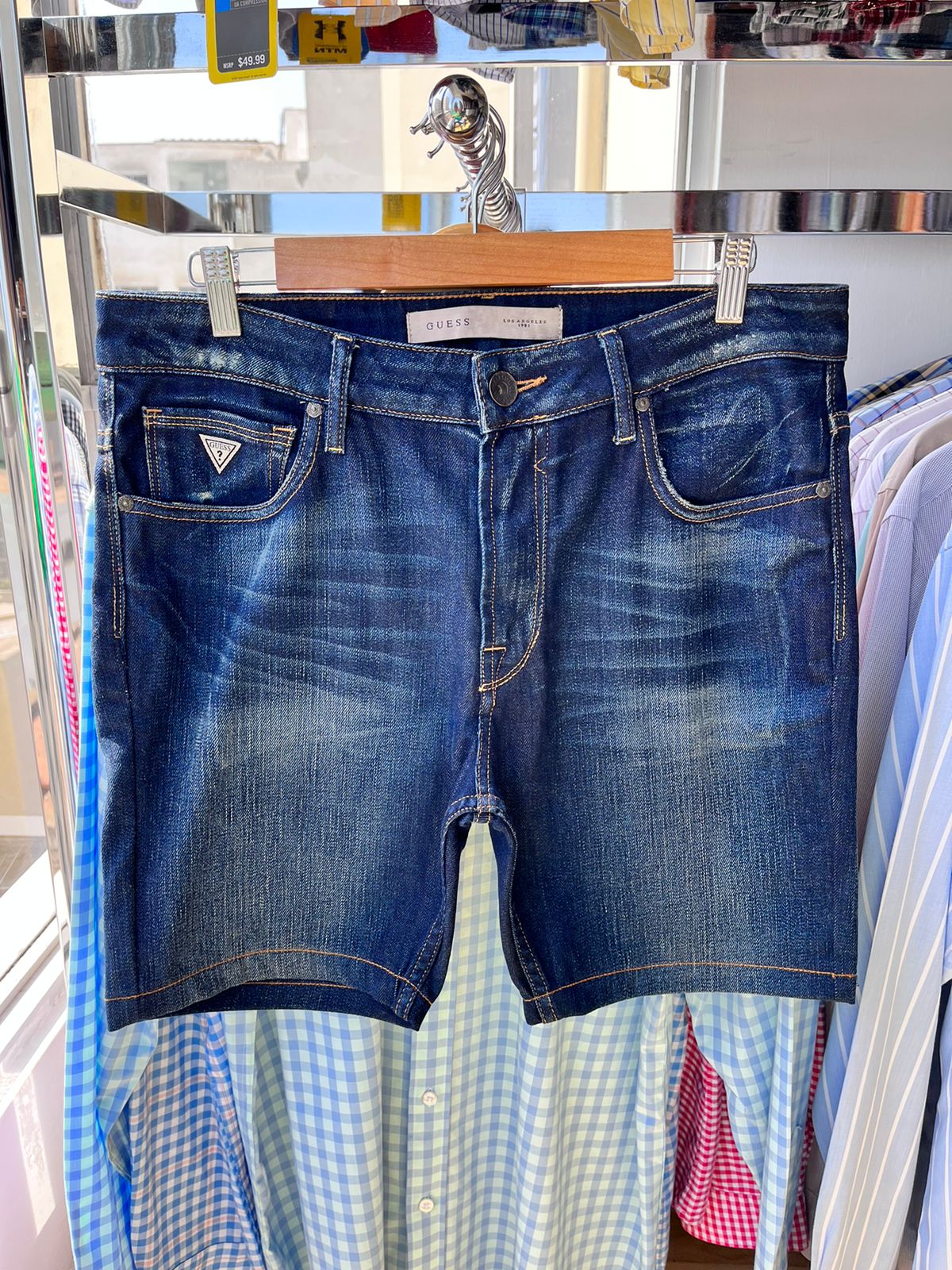 Shorts de hombre Guess, denim lavado medio, diseño de 5 bolsillos, logo triangular en bolsillo delantero.